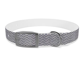 Puede incluir: Un collar de perro blanco y gris con estampado, hebilla y anilla en D plateadas.
