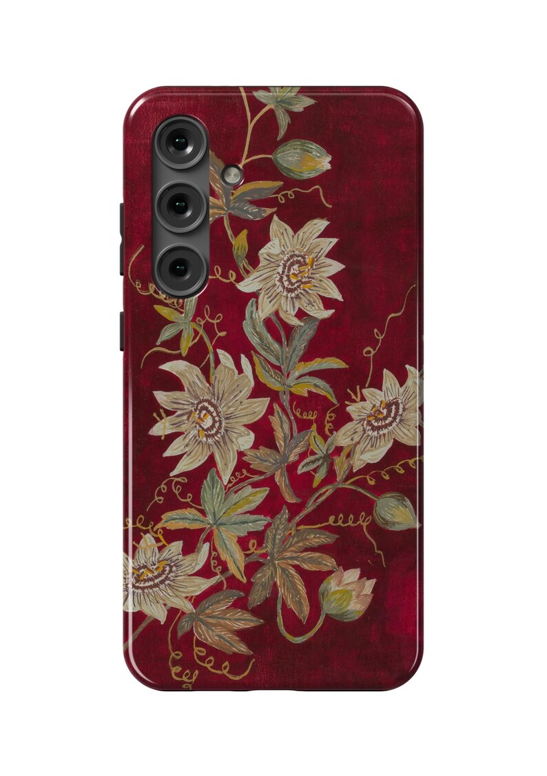 May include: A red phone case with a floral design featuring white flowers and gold accents.