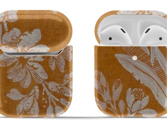 May include: A brown and white floral patterned Airpods case with a silver keychain.