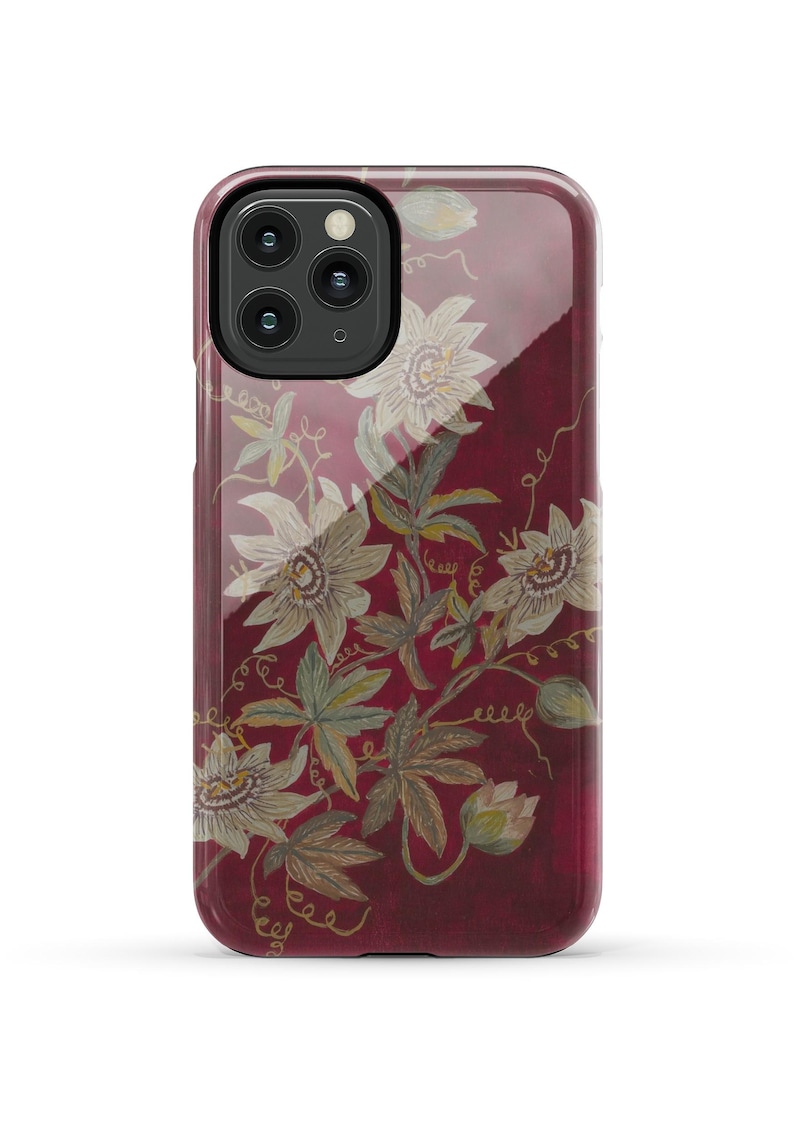 May include: A red phone case with a floral design featuring white flowers and green leaves. The case has a clear back and a black camera cutout.