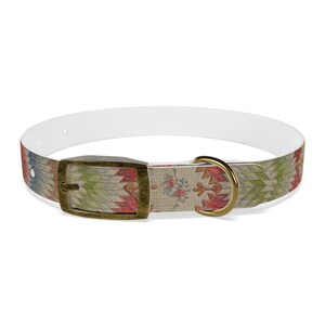 May include: A white dog collar with a colorful geometric pattern and a gold buckle and D-ring.