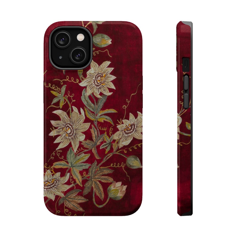 May include: A red phone case with a floral design. The flowers are white with yellow centers and are arranged in a pattern on a dark red background.