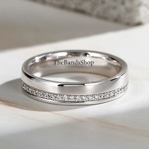Peut inclure: Une alliance en argent avec une rangée de petits diamants autour du bord. La bande est gravée du texte "TheBandsShop".