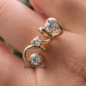 Faixa de design de redemoinho de ouro amarelo 14k, faixa de diamante de moissanita com corte brilhante redondo 0,38 TCW, faixa de carta de amor sinuosa, faixa de proposta de três pedras