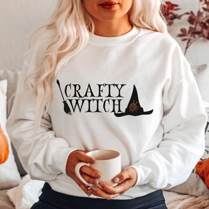 Crafty Witch Halloween Crewneck Sweatshirt. Soft and spooky gift is a treat for knitters and fiber artists.