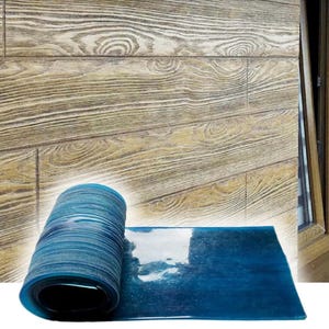 May include: A flexible, translucent blue silicone mat featuring a textured surface with a wood grain pattern. The mat is partially rolled into a cylinder on one side, while the other side lies flat, showcasing the detailed embossed wood texture.