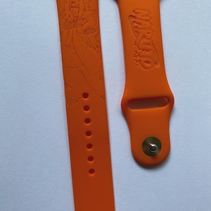 Può includere: Cinturini per orologi in silicone arancione. Un cinturino presenta un design dettagliato di un personaggio, mentre l'altro mostra la parola "NARUTO" in un carattere stilizzato. I cinturini hanno una chiusura a perno e foro.