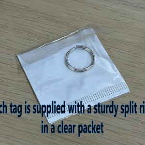 May include: A silver split ring in a clear plastic packet. Each tag is supplied with a sturdy split ring in a clear packet.
