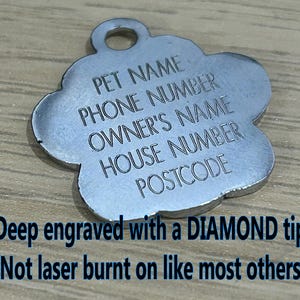 May include: Silver paw-shaped pet ID tag with engraved text: "PET NAME", "PHONE NUMBER", "OWNER'S NAME", "HOUSE NUMBER", "POSTCODE". The tag is deep engraved with a diamond tip, not laser burnt.