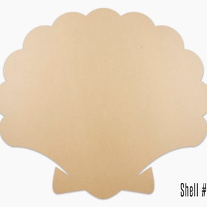 May include: A beige wooden cutout of a seashell with a scalloped edge. The shell has a small bow at the bottom. The text "Shell #02" is printed below the shell.