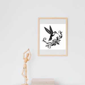K&ouml;nnte beinhalten: Schwarz-wei&szlig;-Illustration eines Kolibris im Flug, dessen Schnabel eine Blume ber&uuml;hrt. Der Kolibri ist von stilisierten floralen Elementen umgeben.