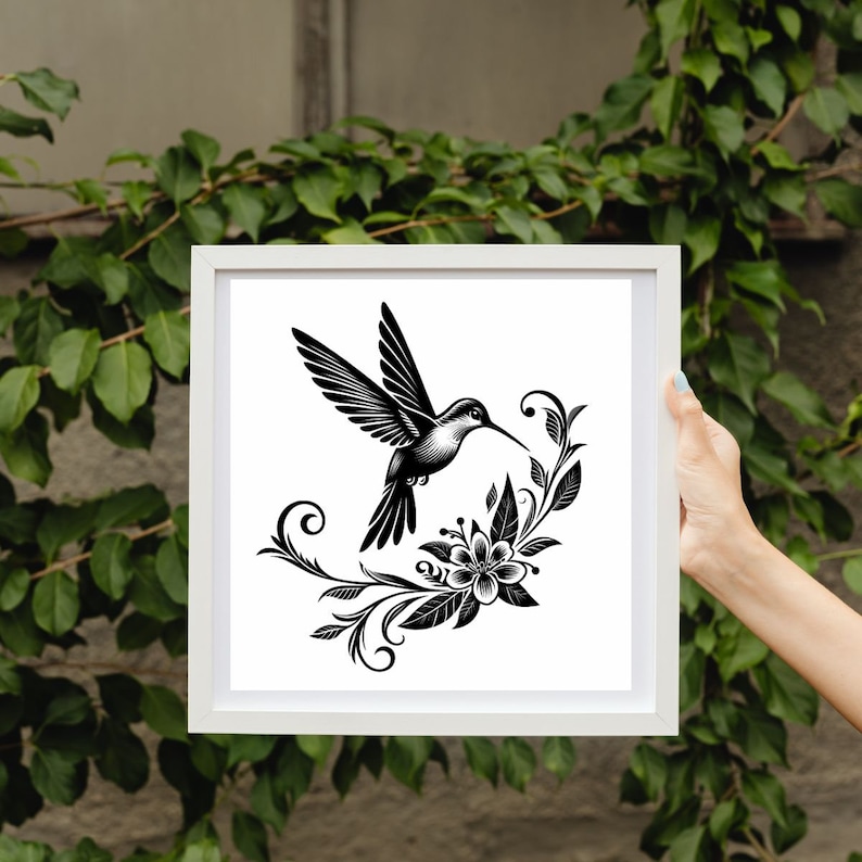 K&ouml;nnte beinhalten: Eine Schwarzwei&szlig;illustration eines Kolibris im Flug, mit seinem Schnabel, der auf eine stilisierte Blume mit filigranen Details gerichtet ist. Der Kolibri ist von wirbelnden floralen Elementen umgeben.