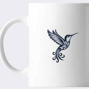 May include: White ceramic mug with a blue hummingbird design. The hummingbird is stylized with intricate details and is flying with its wings spread.
