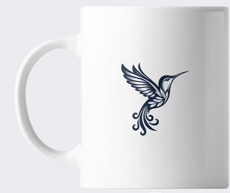 May include: White ceramic mug with a blue hummingbird design. The hummingbird is stylized with intricate details and is flying with its wings spread.