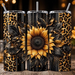 May include: Three stainless steel tumblers with straws. The tumblers feature a design of a large sunflower with black leaves and gold accents. The background is black with gold glitter and leopard print.