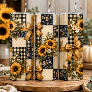 Peut inclure: Trois gobelets cylindriques avec pailles en métal, présentant un motif patchwork de carreaux vichy noir et blanc, de rayures crème et de motifs floraux bleu marine. Chaque gobelet est orné de tournesols jaunes et de nœuds dorés.