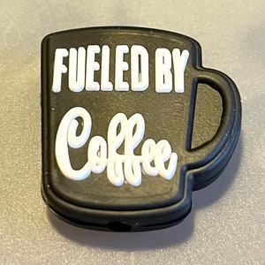 May include: Black silicone charm shaped like a coffee mug with the text "Fueled by Coffee" in white.