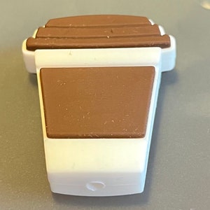 May include: A white and brown silicone coffee cup shaped keychain.