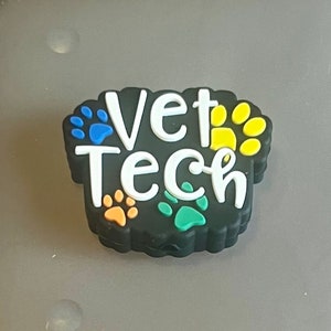 May include: Black charm with the words "Vet Tech" in white lettering and colorful paw prints around the words.