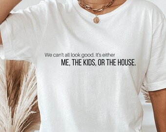 May include: White oversized t-shirt with the text "We can't all look good. It's either ME, THE KIDS, OR THE HOUSE."