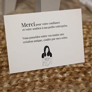 K&ouml;nnte beinhalten: Eine wei&szlig;e Karte mit schwarzem Text, der lautet: "Merci pour votre confiance et votre soutien &agrave; ma petite entreprise. Vous poss&eacute;dez entre vos mains une cr&eacute;ation unique, coul&eacute;e par mes soins."
