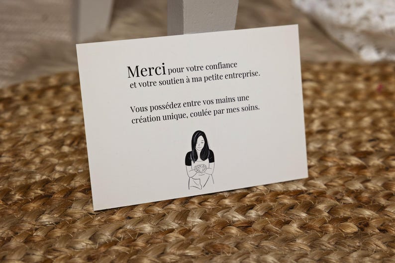 K&ouml;nnte beinhalten: Eine wei&szlig;e Karte mit schwarzem Text, der lautet: "Merci pour votre confiance et votre soutien &agrave; ma petite entreprise. Vous poss&eacute;dez entre vos mains une cr&eacute;ation unique, coul&eacute;e par mes soins."