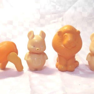 Könnte beinhalten: Eine Sammlung von fünf kleinen Plastiktier-Spielzeugen. Die Spielzeuge umfassen einen Esel, einen Löwen, zwei Kaninchen und einen Affen. Der Esel und der Löwe sind orange, die Kaninchen sind hellbraun und der Affe ist braun.
