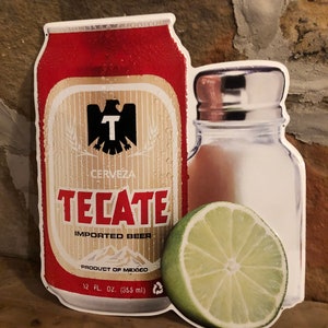 May include: A red and white metal sign featuring a can of Tecate beer, a salt shaker, and a lime wedge. The can has the text "Tecate Imported Beer" and "Product of Mexico". The sign is 12 fluid ounces (355 ml).