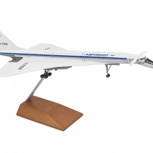 Może przedstawiać: Biały model samolotu z niebieskimi i czerwonymi oznaczeniami. Samolot stoi na drewnianym stojaku i ma napis "Aeroflot" i "CCCP-77109" na boku.