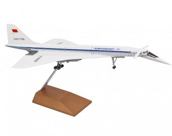 Pode incluir: Um modelo de avião branco com marcas azuis e vermelhas. O avião está em um suporte de madeira e tem o texto "Aeroflot" e "CCCP-77109" no lado.
