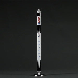 May include: A white and black model rocket with the words "SpaceX" and "NASA" printed on the side. The rocket is on a black stand.