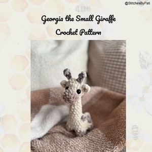 May include: A crochet pattern for a small giraffe amigurumi toy. The pattern is called "Georgia the Small Giraffe" and is an intermediate level pattern. The giraffe is sitting on a blanket and is made with white and brown yarn.