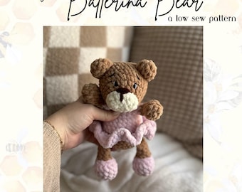 Puede incluir: Un oso de bailarina de crochet marrón con un tutú rosa. El oso está siendo sostenido por una mano. La imagen tiene el texto "Burry the Ballerina Bear" y "a low sew pattern".
