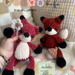 May include: Two crocheted fox plushies. One is a deep red with a white flower and the other is a reddish-brown with a white tail and acorn. The text reads "FREYA the fox" and "a no sew pattern".