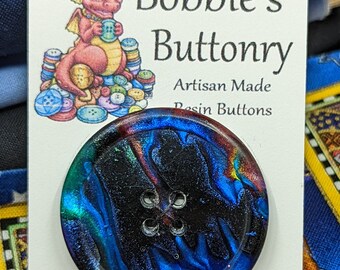 May include: A blue, black, and red resin button with a swirl pattern. The button has four holes and is artisan made.