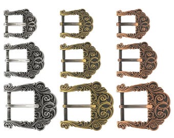 Può includere: Tre set di fibbie per cintura in metallo ornate, in finiture argento, oro e rame. Ogni fibbia presenta un design a scorrimento dettagliato.