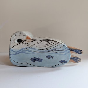 May include: A set of three ceramic mugs with a speckled, cream-colored glaze. Each mug features a different hand-painted design: a blue and green mountain range, a yellow sun, and a blue crescent moon. The mugs have a minimalist, modern aesthetic.