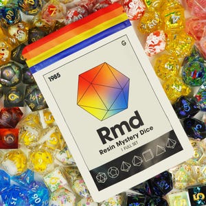 Puede incluir: Un juego completo de dados de resina coloridos en una bolsa de plástico transparente con una tarjeta blanca que dice "Rmd Resin Mystery Dice 1 Full Set". La tarjeta tiene una forma geométrica de arcoíris.