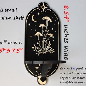 May include: Black wooden shelf with a crescent moon and stars design. The shelf is 8.54 inches wide and has a 2.75 by 3.75 inch shelf area. It can hold 6 pendulums and small items like selenite, crystals, air plants, tea lights, or small jewelry.