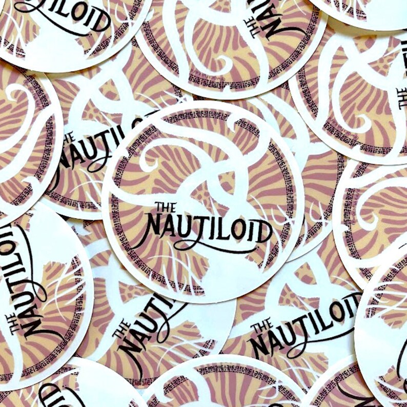 May include: A stack of round stickers with a pink and yellow zebra-like pattern. The stickers feature the text "The Nautiloid" in black script.