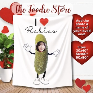 May include: White blanket with the text "I ❤️ Pickles" and a cartoon pickle with a person's face. The blanket also has the text "Add the photo & name of your loved one!" and size options: 76x102cm, 127x152cm, 152x203cm.