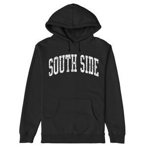 以下が含まれることがあります： 「SOUTH SIDE」という文字がアーチ状のフォントで書かれた、白い擦り切れたグラフィックが施された黒いフード付きスウェットシャツです。