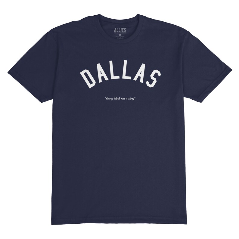 Puede incluir: Una camiseta azul marino con un gr&aacute;fico blanco en arco "DALLAS" y el texto "Every block has a story" debajo. La camiseta est&aacute; hecha por Allies.