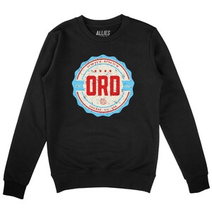 May include: Black crew neck sweatshirt featuring a distressed circular graphic. The graphic includes the letters "ORD" in red, set within a blue and white border. The text "Chicago, IL, USA" is at the bottom of the design.