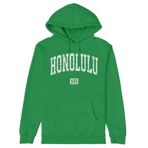 May include: A green hooded sweatshirt with the text "HONOLULU" in white with a distressed look. The text is in an arch shape with the number "808" underneath.