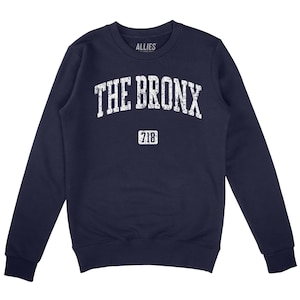 May include: Navy blue sweatshirt with a white distressed graphic that says "THE BRONX" in an arch with "718" underneath.