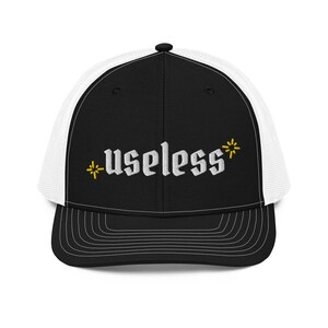 May include: Black and white trucker hat with a white embroidered design that says "*useless*" with a yellow asterisk on each side.