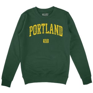 May include: A dark green sweatshirt with a yellow vintage-style graphic that says "PORTLAND 503".