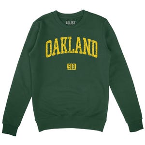 May include: A dark green sweatshirt with a yellow vintage-style graphic that says "Oakland 510".