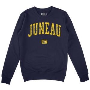 May include: Navy blue sweatshirt with a yellow vintage-style graphic that says "JUNEAU 907".